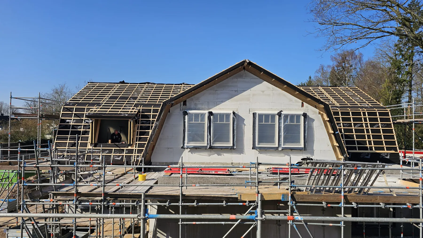 Vrijstaande woning in aanbouw met dakwerk en steigers