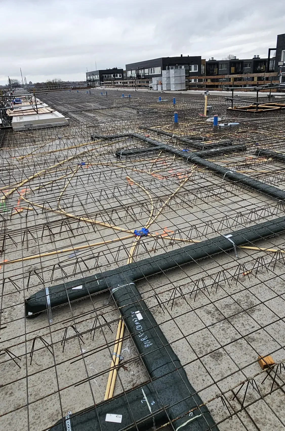 Overzicht van een omvangrijke bouwvloer met wapening en installaties